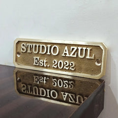 Brass plaque with custom text on a reflective surface.