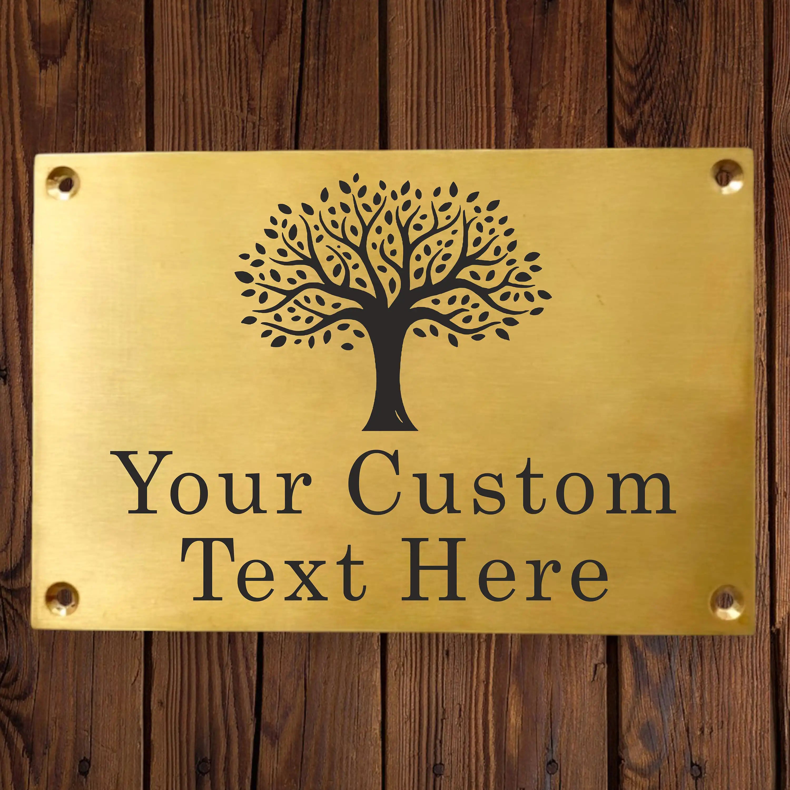 Brass plaque with tree design and customizable text engraving on a wooden background