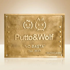 Brass plaque with custom branding and contact information on a beige background