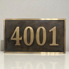 House number sign with gold numbers '4001' on a reflective surface.