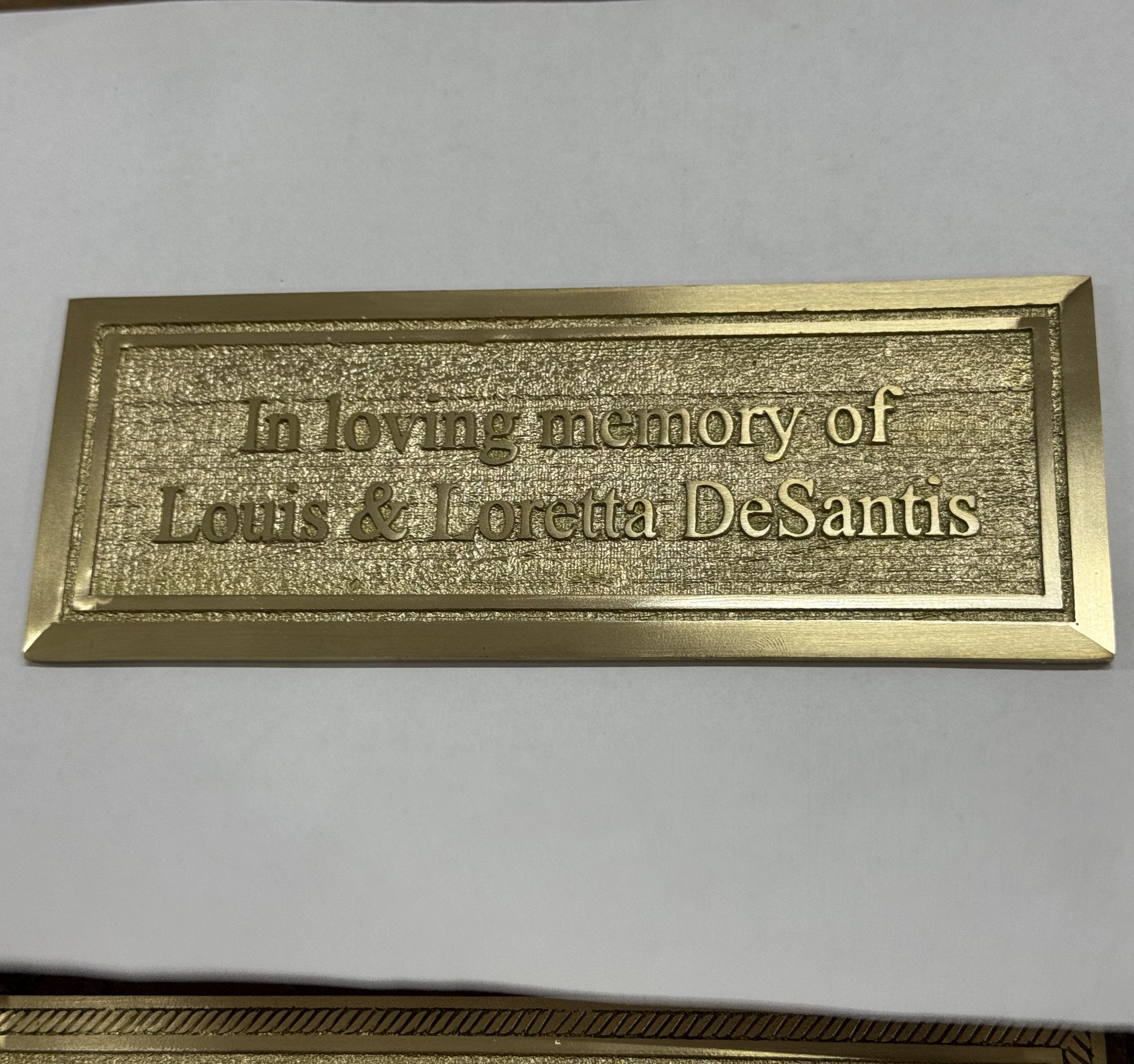 Gold plaque with engraved text on a white background