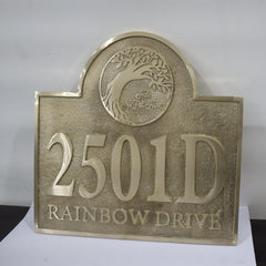 Bronze-colored house number sign with '2501D' and 'Rainbow Drive' text on a white background