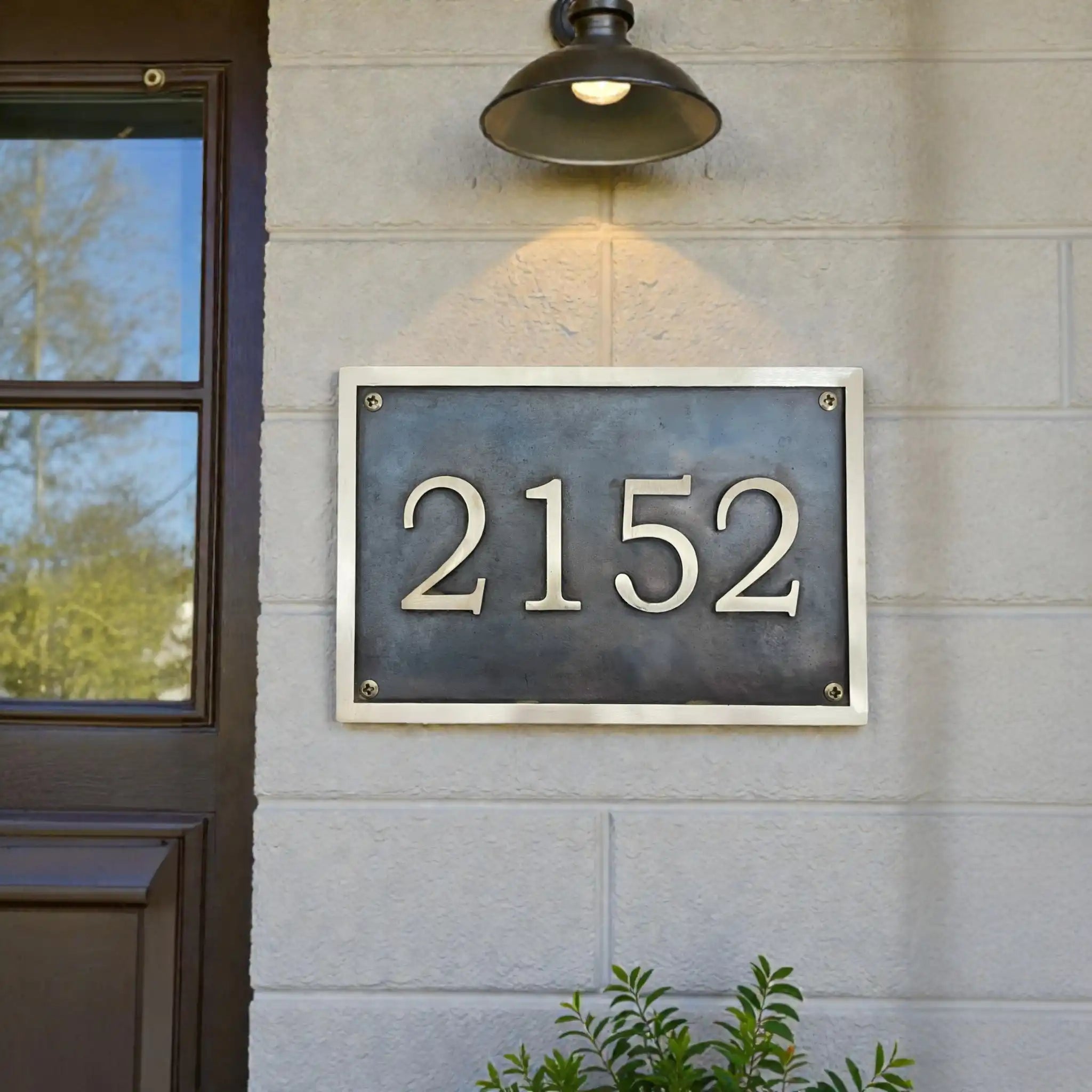 House number '2152' on a metal plaque mounted on a building exterior.
