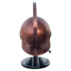 Copper helmet on a black stand against a white background