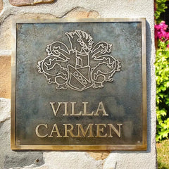 Bronze address plaque with 'Villa Carmen' on a stone wall