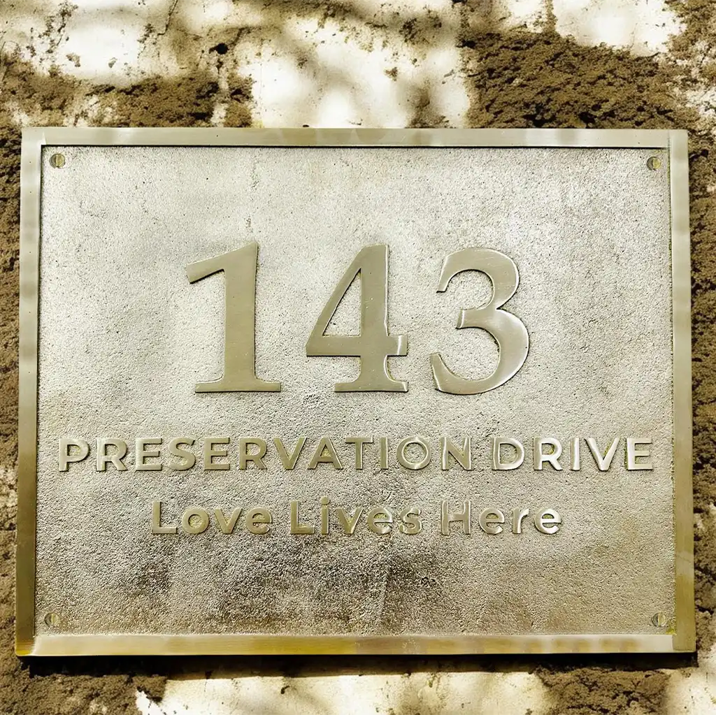 Personalized brass house sign | Brass house number plaque with text on a textured wall background