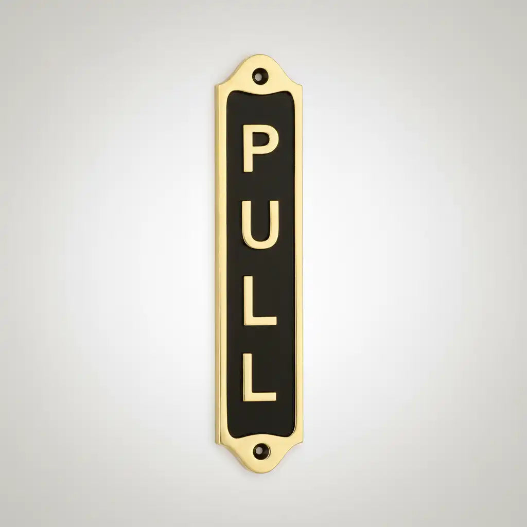 Decorative brass door sign with 'PULL' text on a light gray background