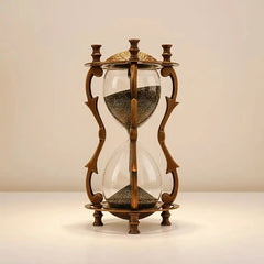 Decorative hourglass with bronze frame and glass bulbs on a beige background