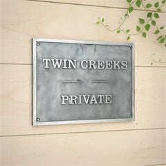 Silver finish brass address plate engraved | Metal sign with  text on a wooden background
