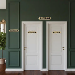 Premium Brass Restroom Door Sign Set  Two white doors labeled 'Ladies' and 'Gents' on a green wall.