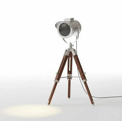 Vintage-style spotlight floor lamp with wooden tripod base and metallic top on a white background