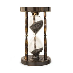 Sand timer hourglass with bronze metal casing on a white background