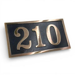 House number plate with '210' on a black background