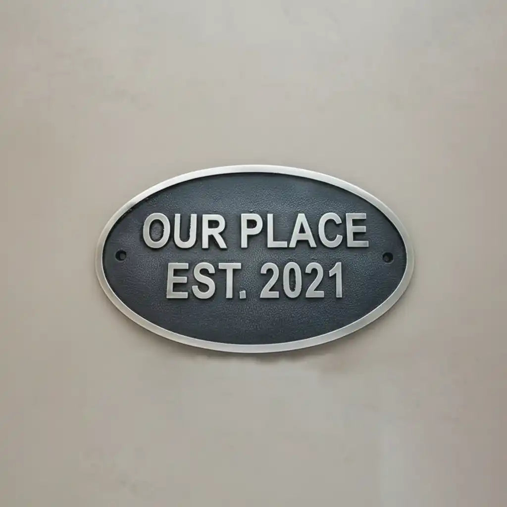 Oval metal sign with 'OUR PLACE EST. 2021' text on a beige background