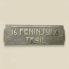House number and street name plaque on a beige wall