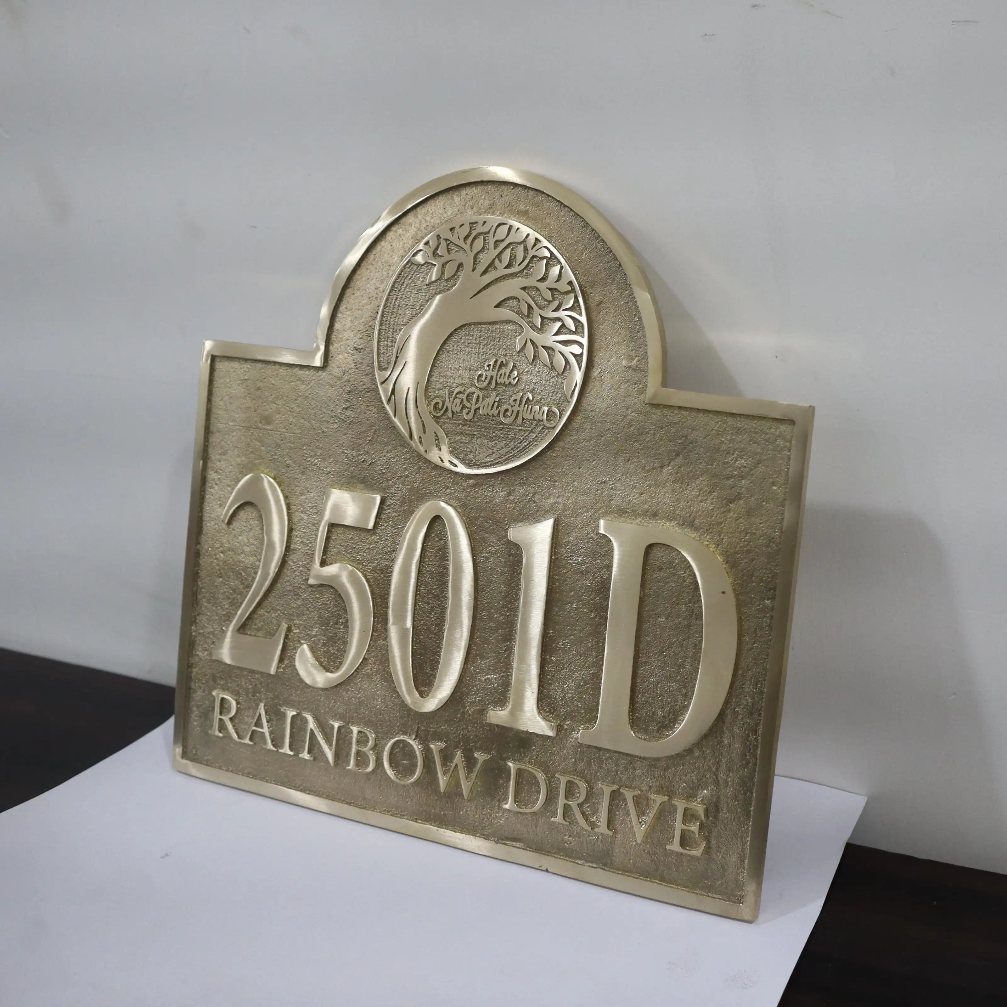Bronze house number sign with '2501D' and 'Rainbow Drive' text on a white background