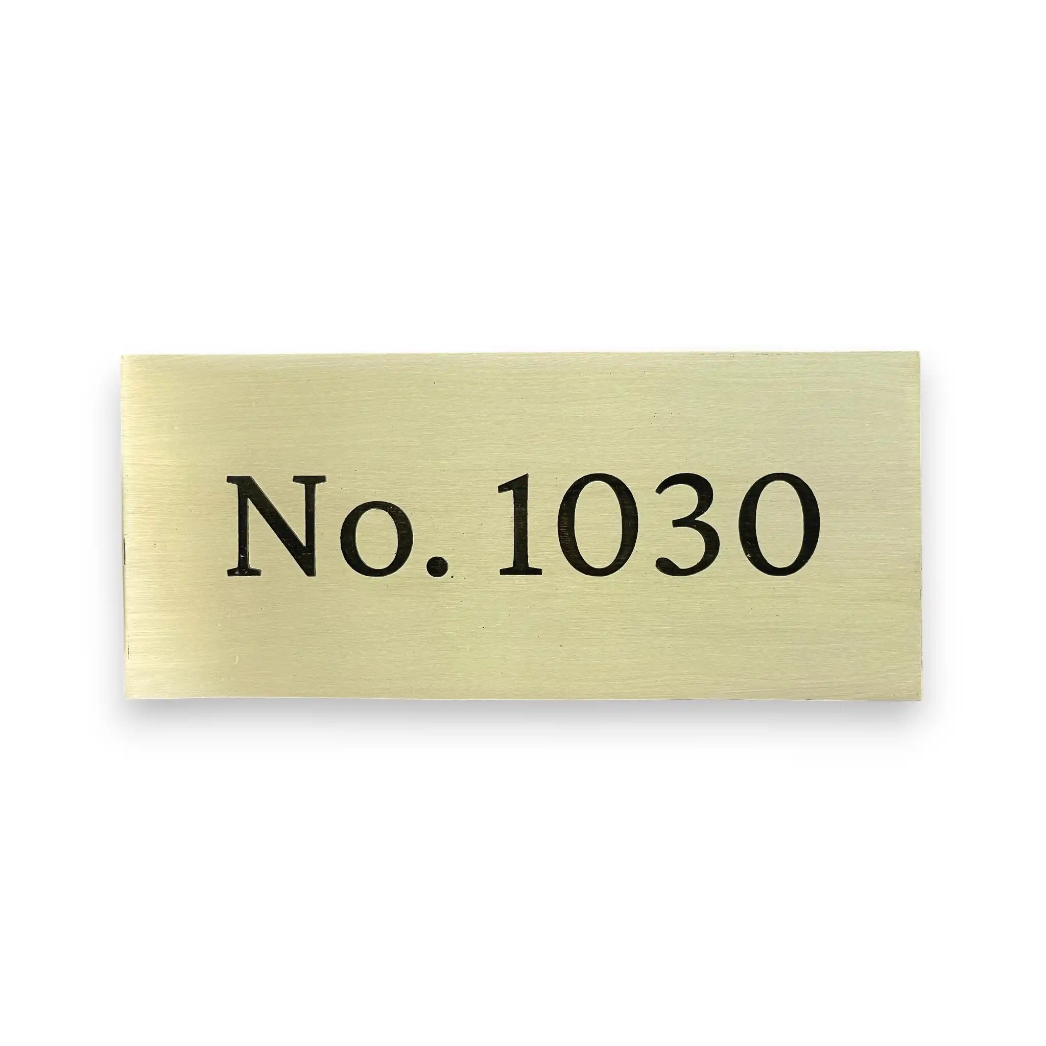 Brass sign with engraving text 'No. 1030' on a white background