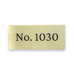 Brass sign with engraving text 'No. 1030' on a white background