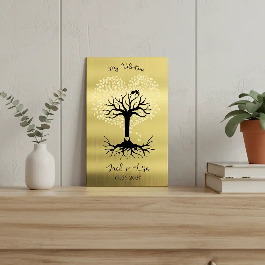 Solid brass engraved sign with a tree design on a wooden shelf with plants and books.