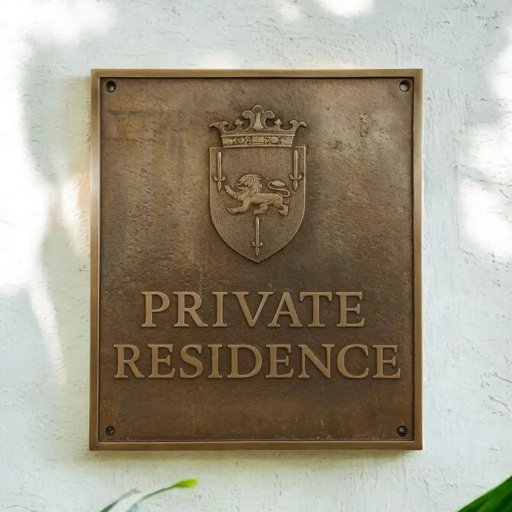 Bronze plaque with a lion emblem and 'PRIVATE RESIDENCE' text on a textured wall. Custom bronze house plaque.