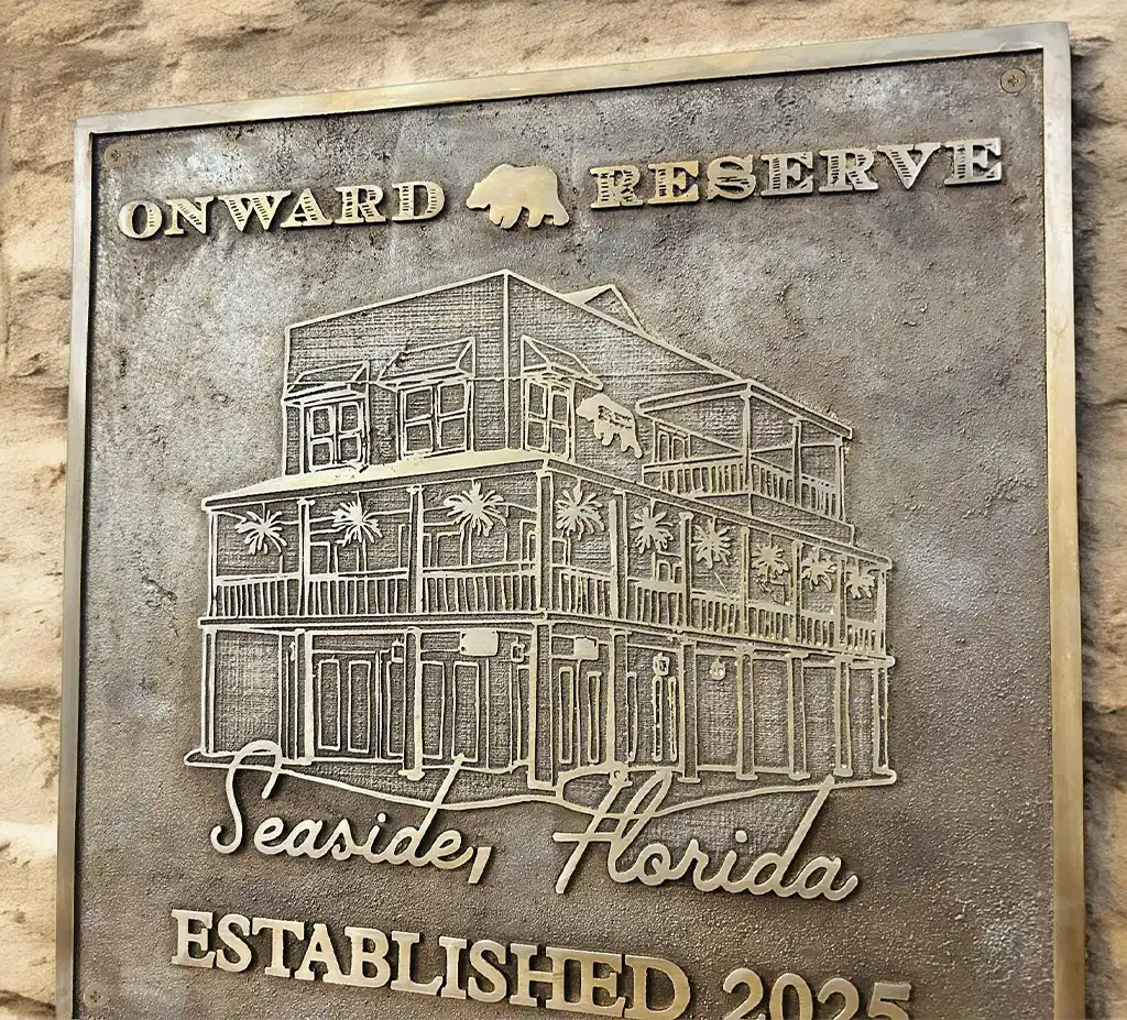 custom cast bronze plaque with architectural design and text on a stone wall