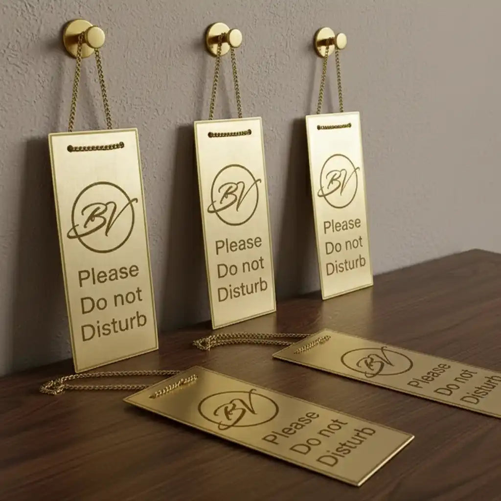 Brass metal tag with engraved signs on a wooden surface and wall.