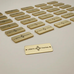 Gold tags with custom branding on a light gray background