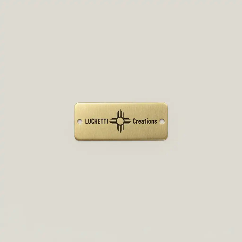 Gold rectangular tag with custom engraving on a light gray background
