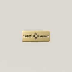 Gold rectangular tag with custom engraving on a light gray background