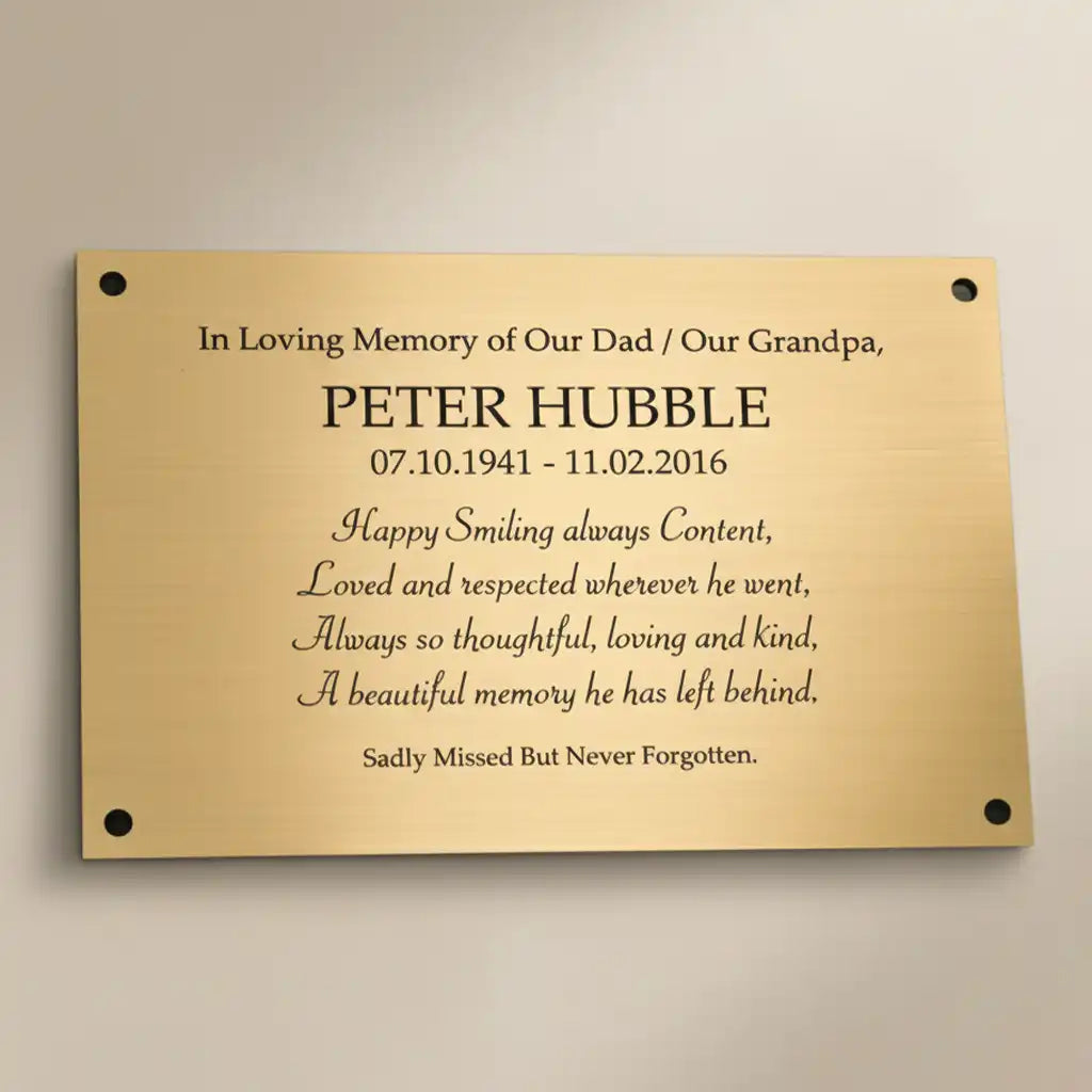 Engraved brass  memorial plaque on a beige background