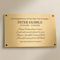 Engraved brass  memorial plaque on a beige background