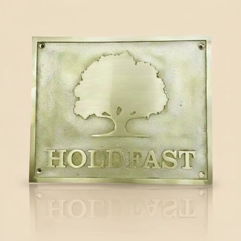 Brass plaque with an embossed tree design and text on a beige background