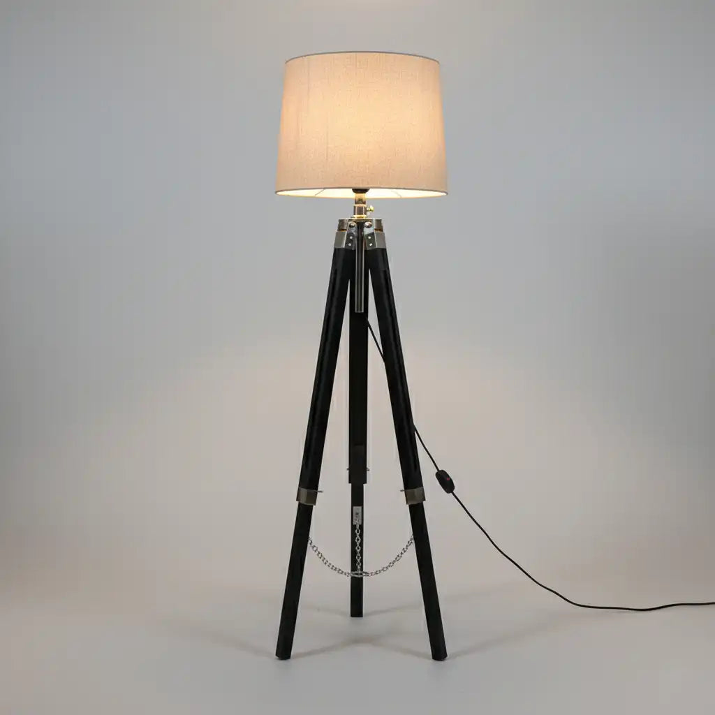 Floor lamp with a beige shade on a tripod base against a gray background