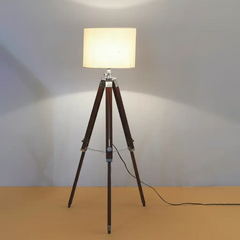 Floor lamp with wooden tripod base on a plain background