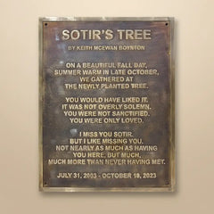 Bronze plaque with engraved text on a beige wall