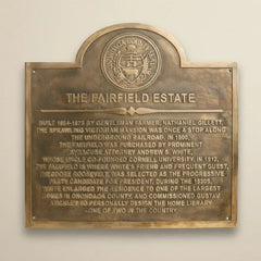 Brass historical home sign on a beige wall
