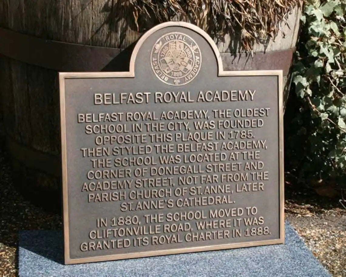 Plaque commemorating Belfast Royal Academy with text and emblem.