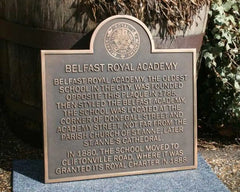 Plaque commemorating Belfast Royal Academy with text and emblem.
