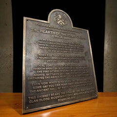 Metal plaque with engraved text on a wooden surface