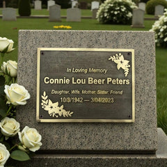 Memorial stone with brass plaque in a cemetery