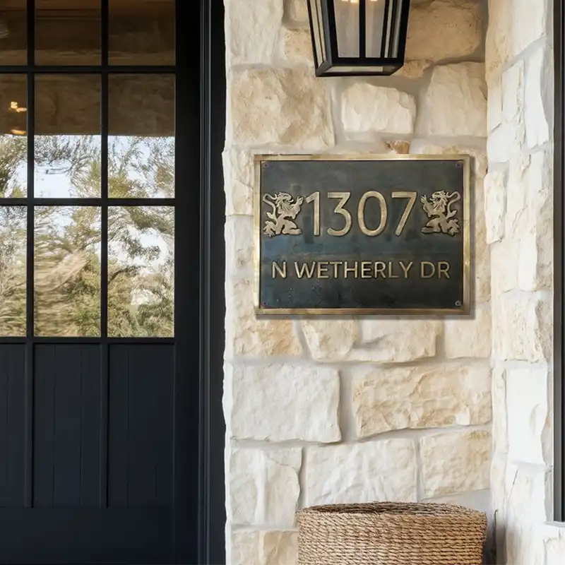 Bronze House number sign on a stone wall next to a door, bronze address numbers sign