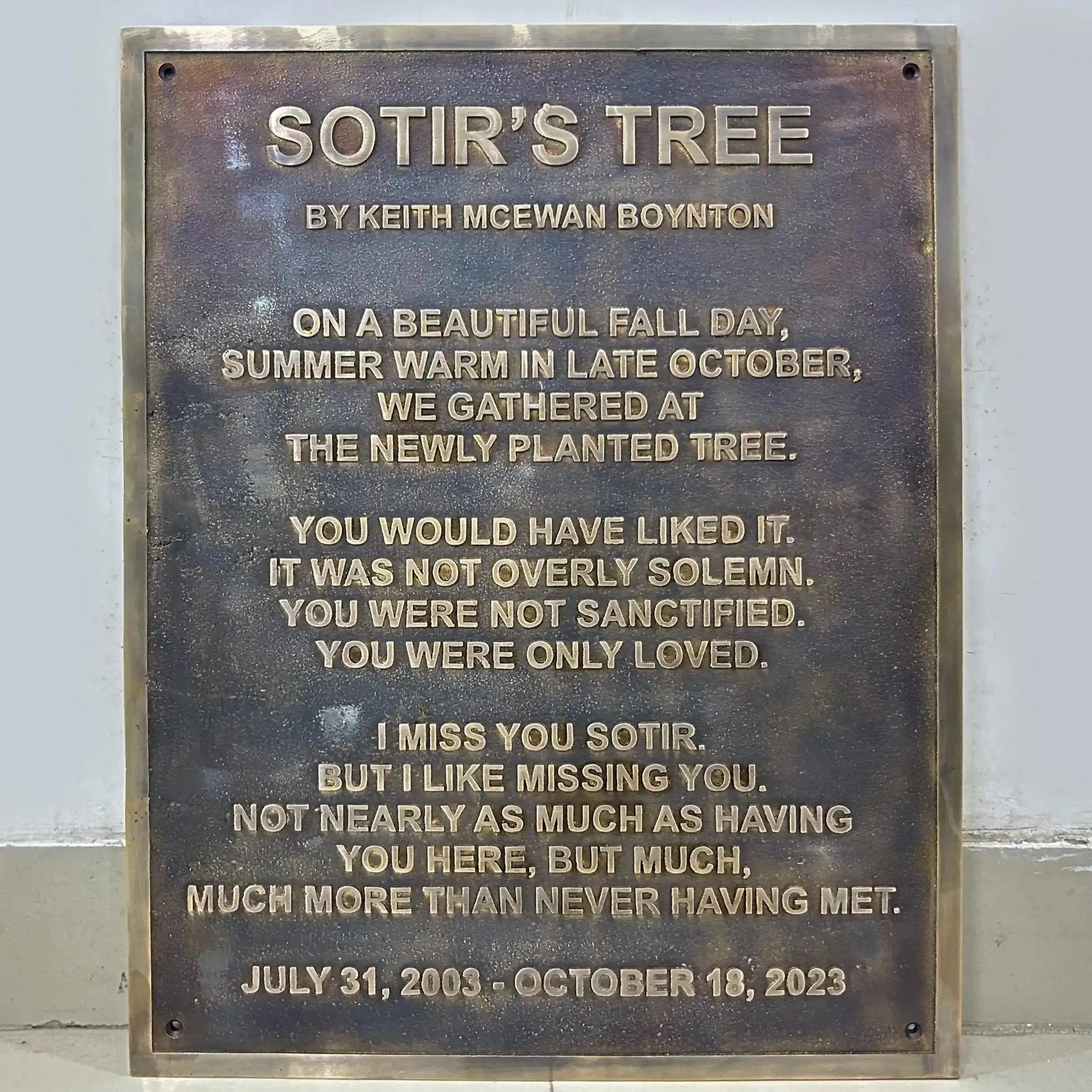 Bronze plaque with engraved text on a white background
