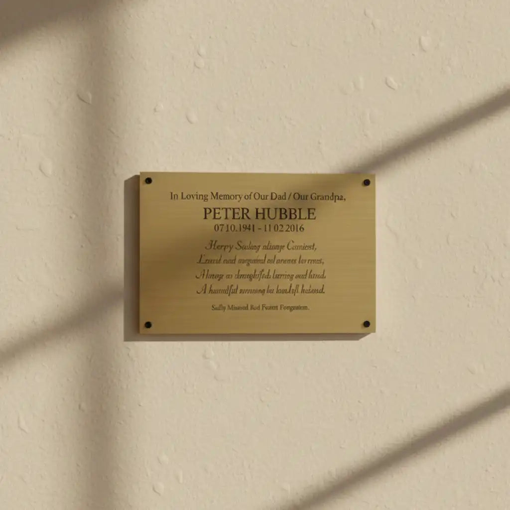 Brass memorial plaque for on a beige wall