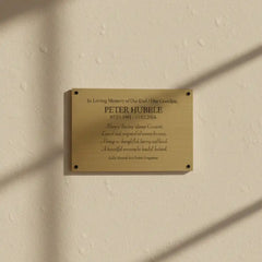 Brass memorial plaque for on a beige wall