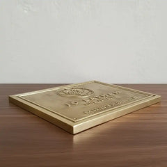 custom brass plaque for entryway | Brass plaque with engraved text on a wooden surface