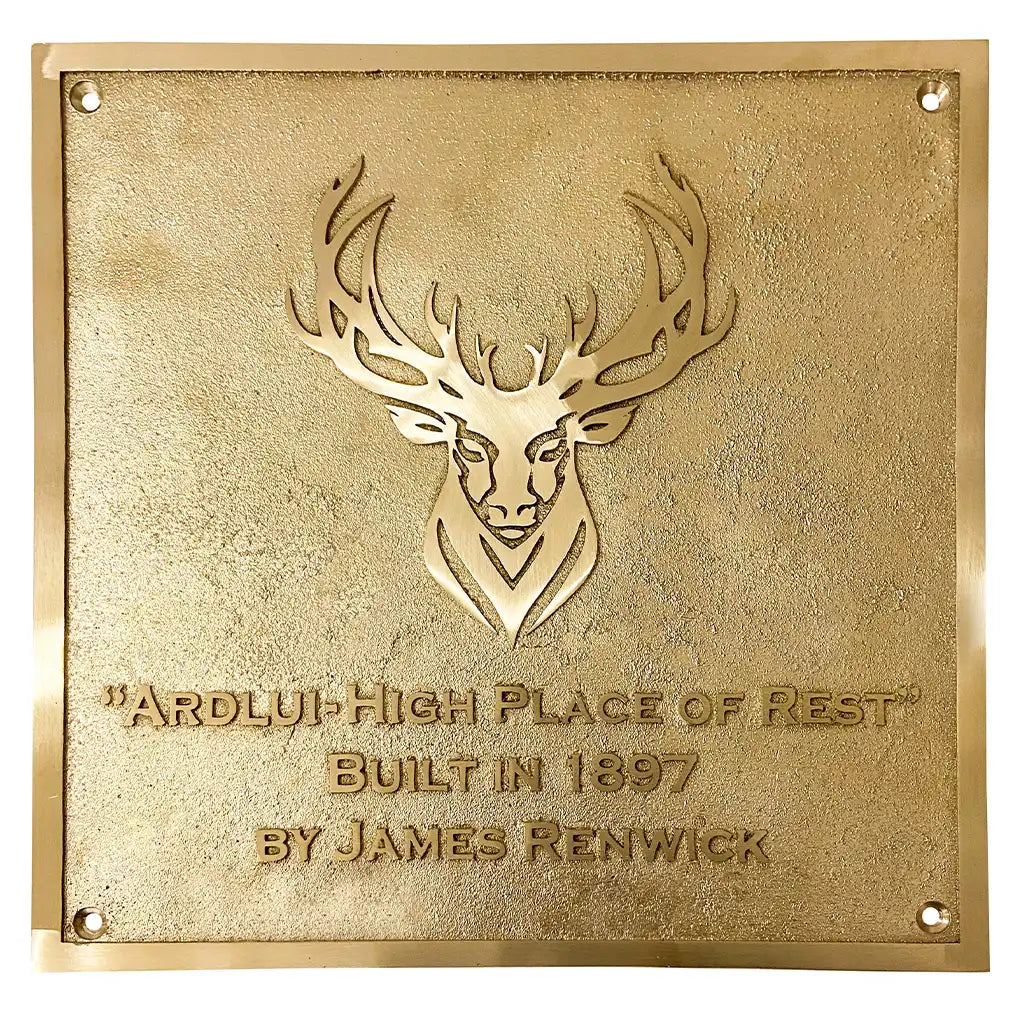 Handcrafted brass house plaque, gold plaque with deer emblem and text on a white background
