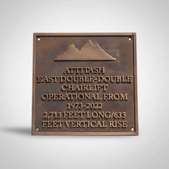custom bronze memorial plaque engraved with a mountain design and operational details of a chairlift.