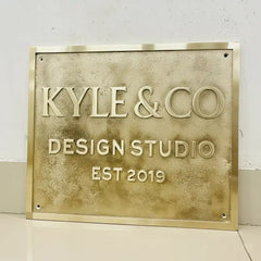 Engraved brass address plaque | Gold plaque with 'KYLE & CO DESIGN STUDIO EST 2019' text on a white background