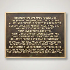 engraved bronze name plaque with engraved text on a plain background