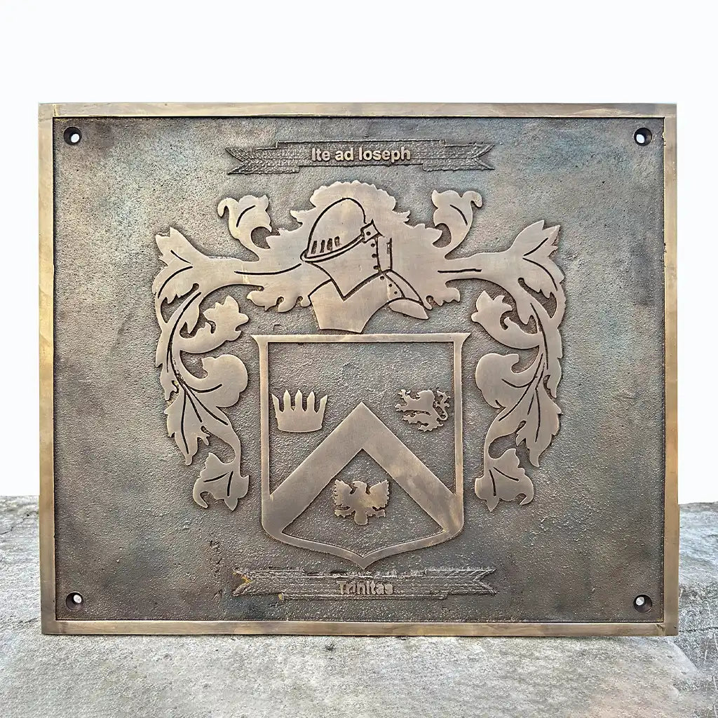 vintage bronze plaque with a coat of arms design on a wooden surface